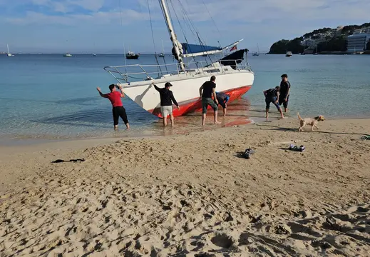 People Around a Beached Sailboat at Son Maties